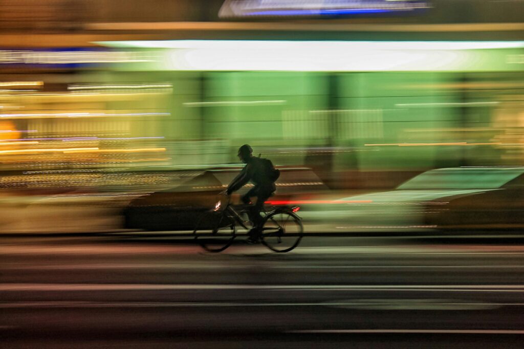 man riding a bicycle on the road at night